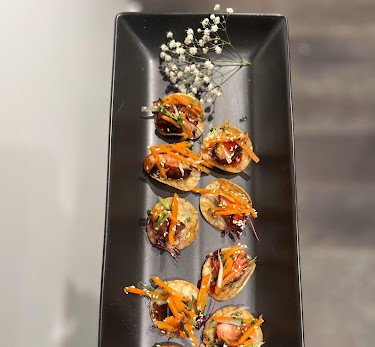 Server presenting Chicken Shar Siu on a tray at a gourmet brunch catered in Boston.