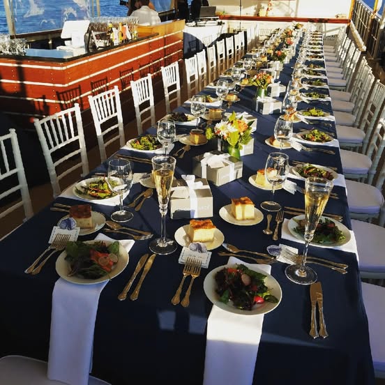 Sophisticated Boston wedding reception table set with champagne glasses, plated salads, elegant place settings, and desserts ready for guests.