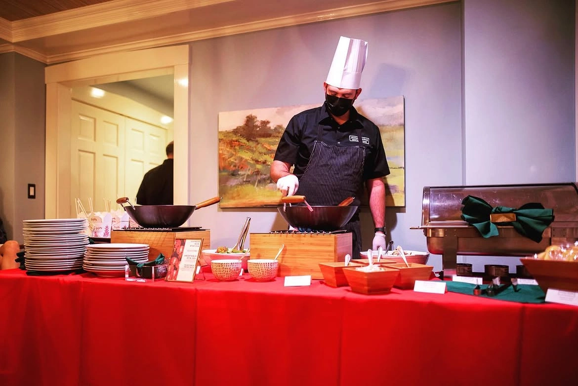 Chef preparing food at a live event station by Johnny Burke Catering & Events.
